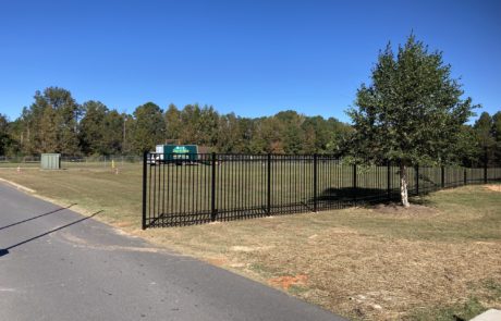 Grassy field with a couple of trees and new, black, aluminum fence